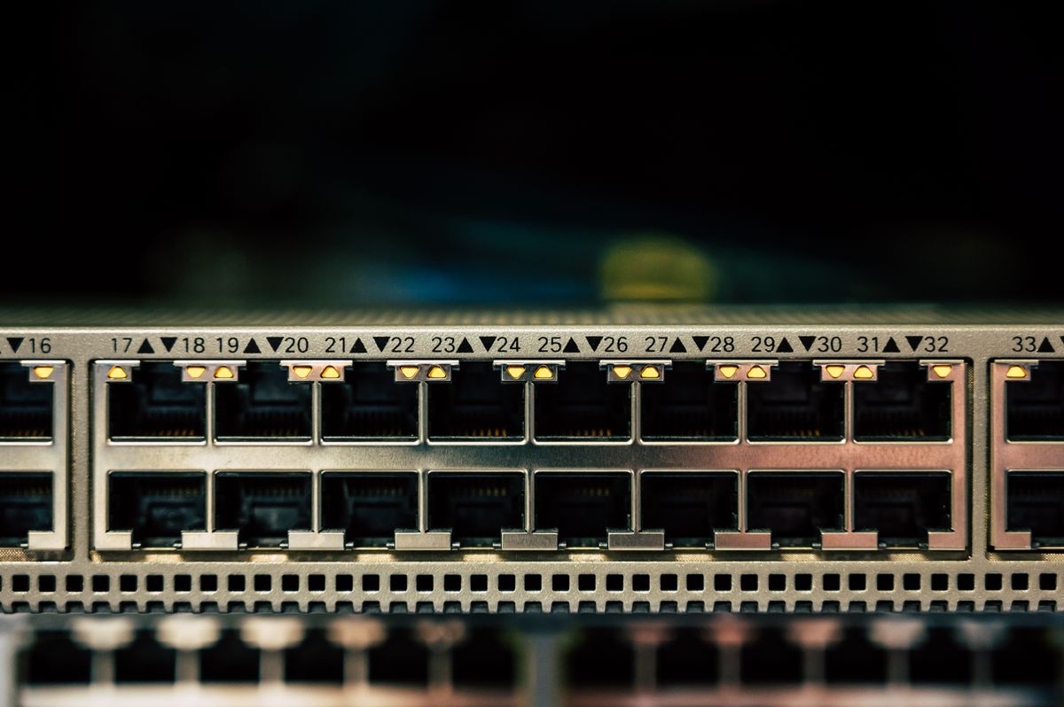 Zbliżenie na panel switcha sieciowego z portami Ethernet i migającymi diodami