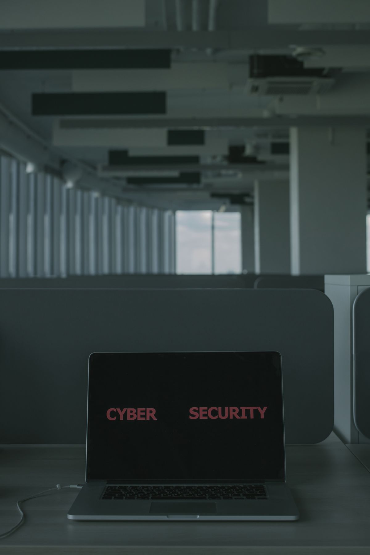 Laptop w biurze z napisem Cyber Security na ekranie