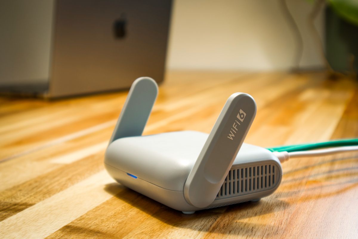 Router WiFi z antenami stojący na drewnianym blacie