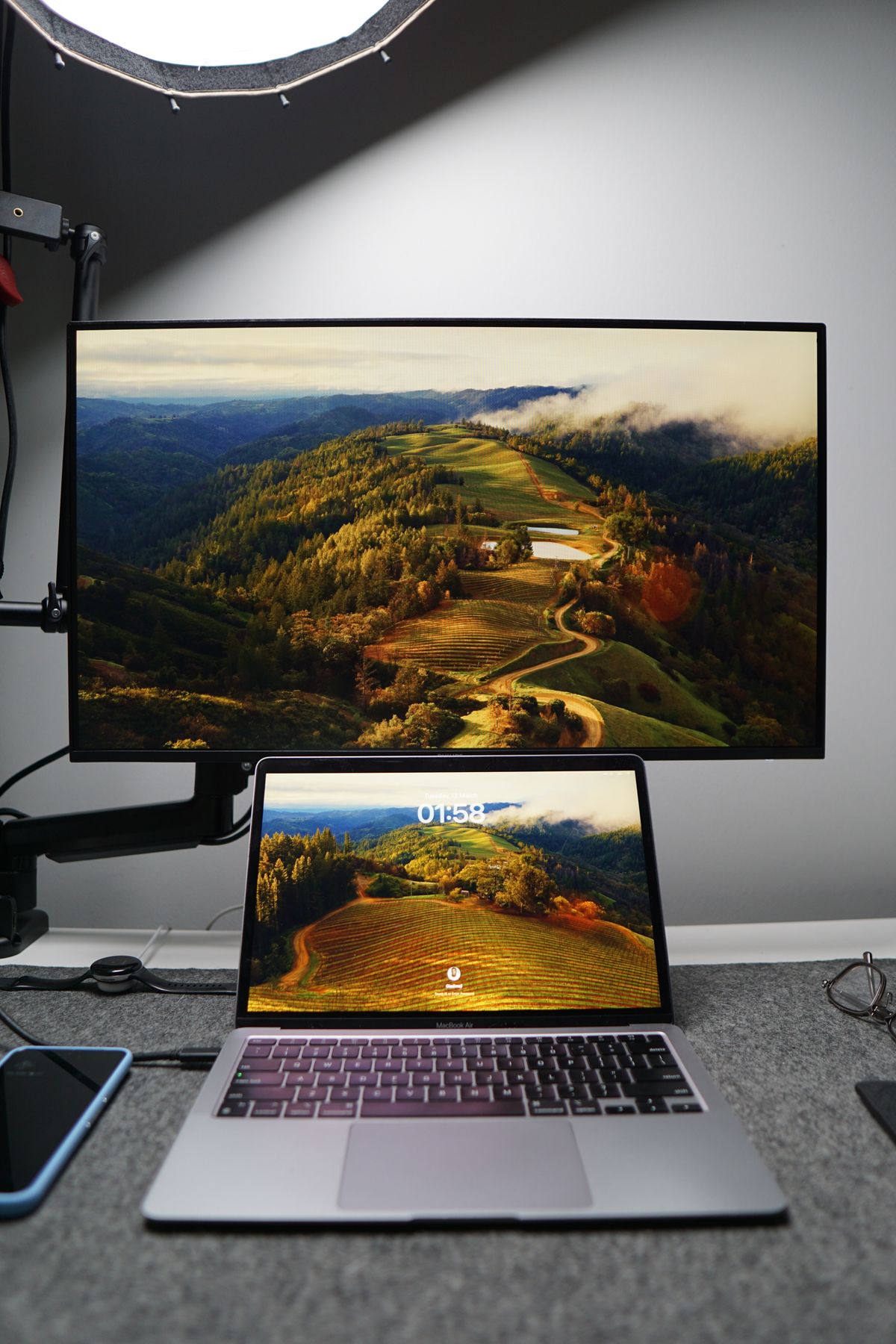 Laptop i monitor wyświetlające ten sam pejzaż na ekranie blokady