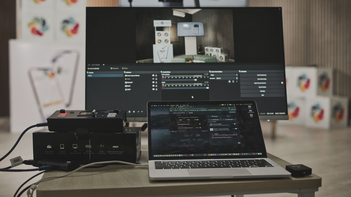 Laptop podłączony kablami do dużego zewnętrznego ekranu