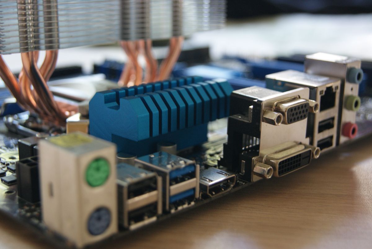 Zbliżenie na tylny panel komputera z portami I/O płyty głównej, widoczne gniazdo sieciowe