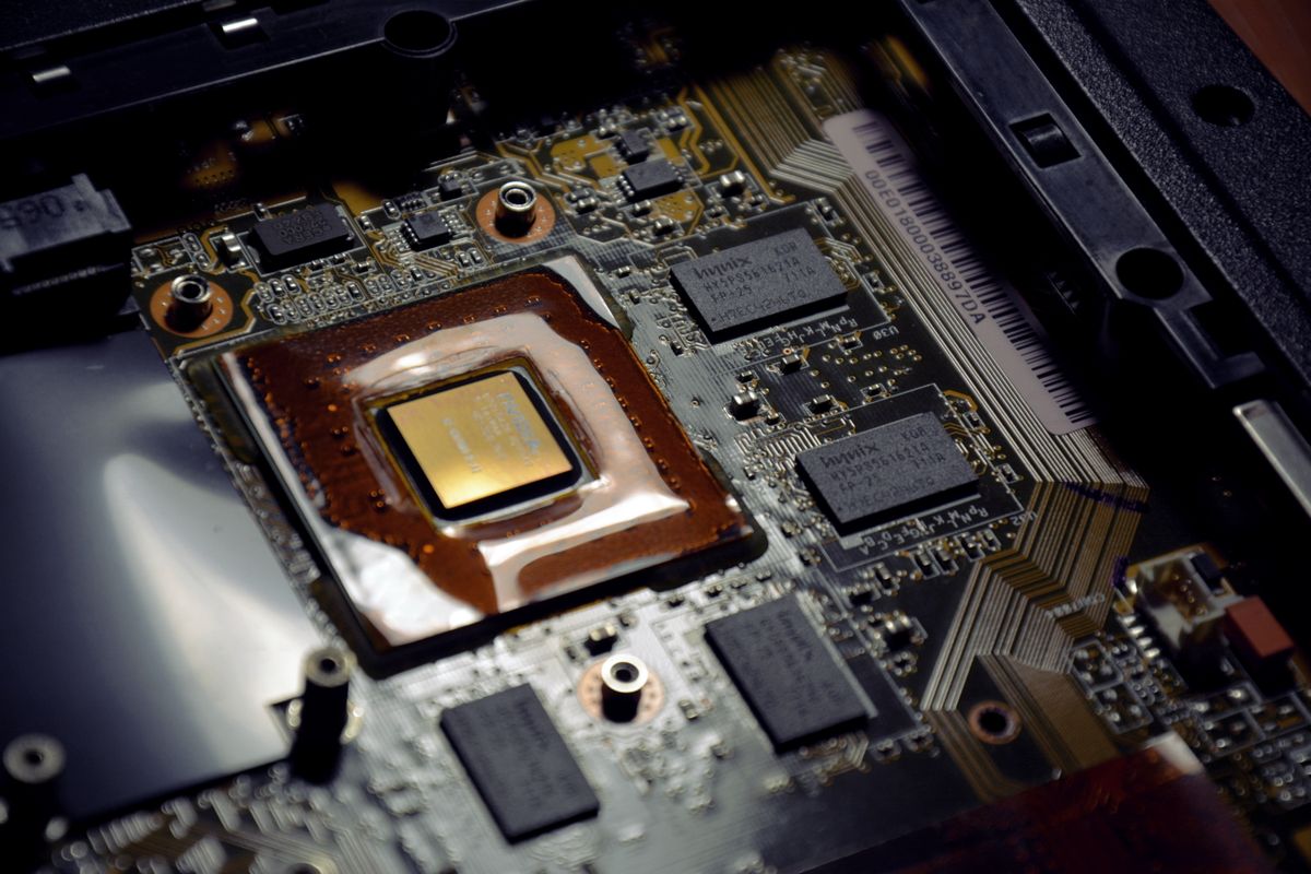Zbliżenie płyty głównej laptopa z procesorem pokrytym pastą termoprzewodzącą