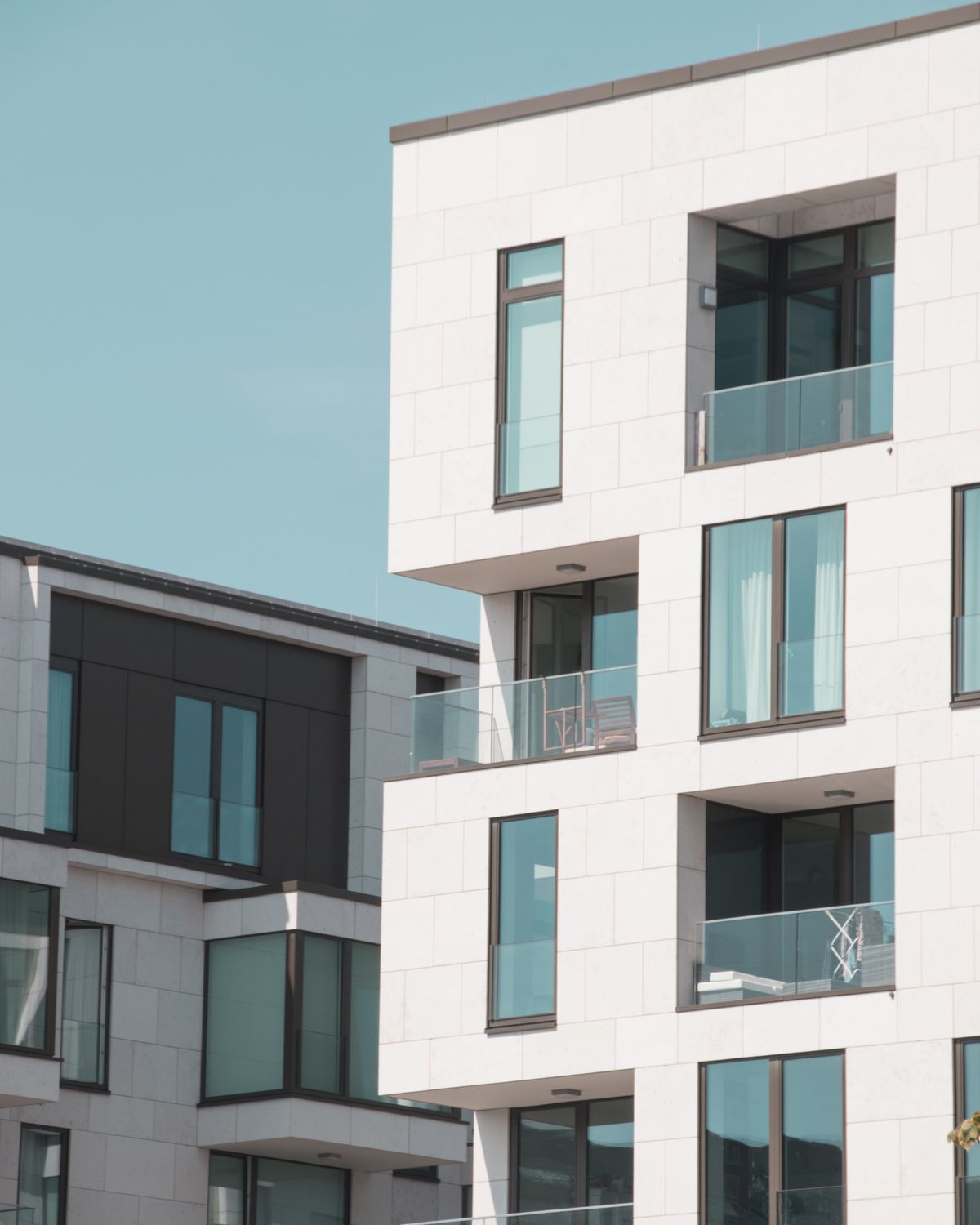 Nowoczesny biały apartamentowiec z przeszklonymi balkonami