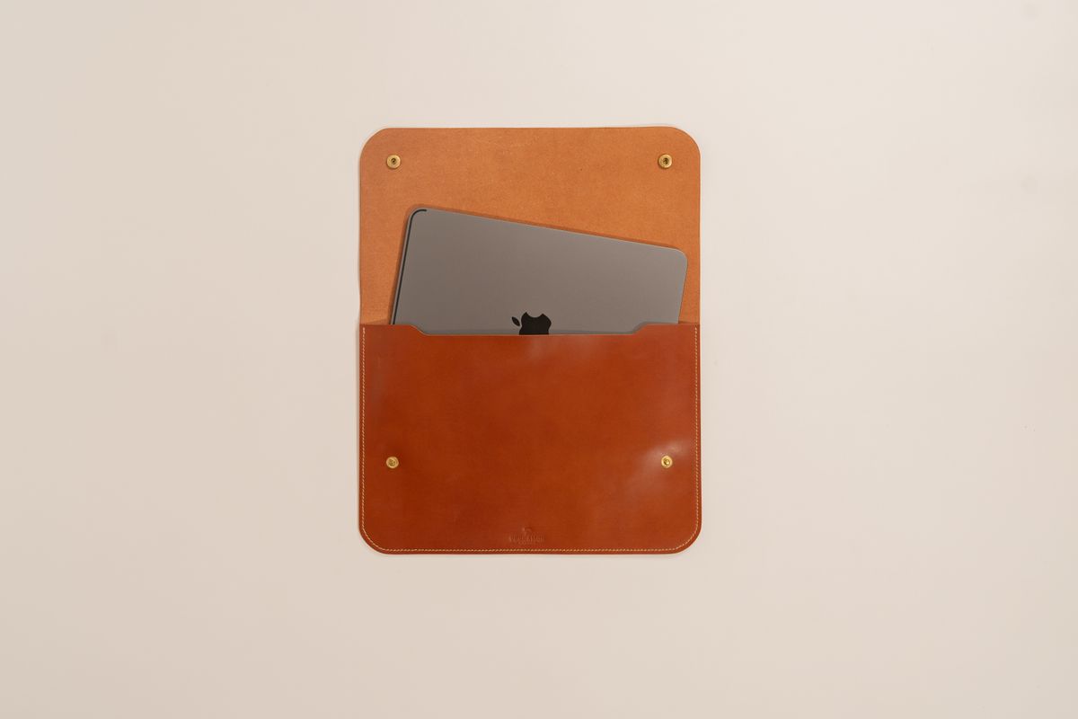 Laptop wsunięty do skórzanego etui podróżnego